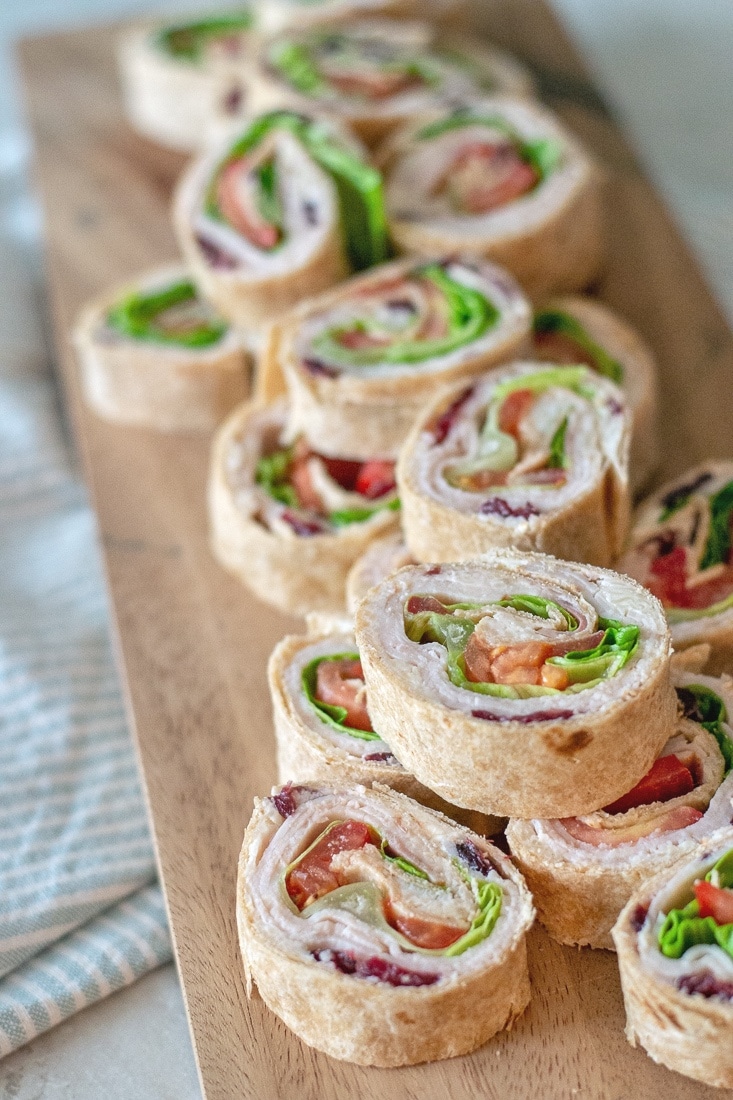 Cranberry Turkey Pinwheels make an awesome cold appetizer for Thanksgiving or even a great, healthier no heat lunch. These are made with a cream cheese, swiss and cranberry spread that makes these extra delicious! 