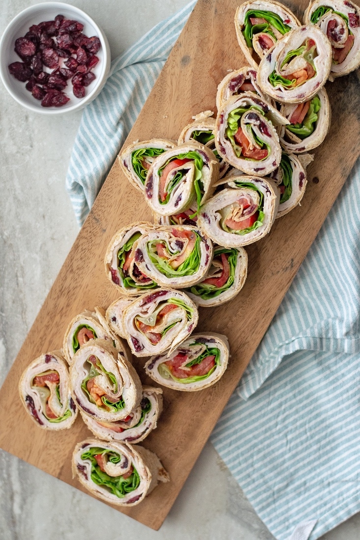 Cranberry Turkey Pinwheels make an awesome cold appetizer for Thanksgiving or even a great, healthier no heat lunch. These are made with a cream cheese, swiss and cranberry spread that makes these extra delicious! 
