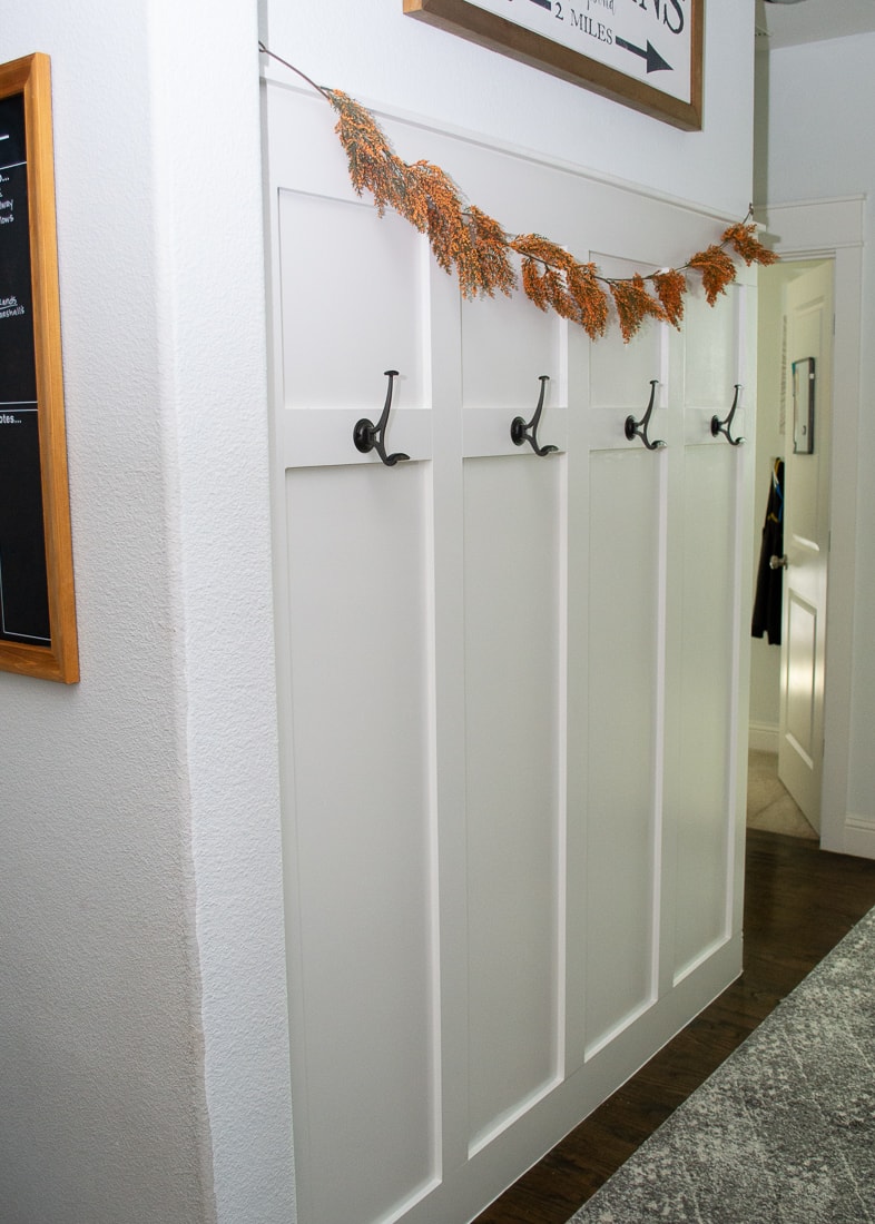 A step by step guide to installing a board and batten molding wall in a hallway with hooks to act as a mudroom. This DIY trim can add a little farmhouse decor to a boring space! #molding #diyproject