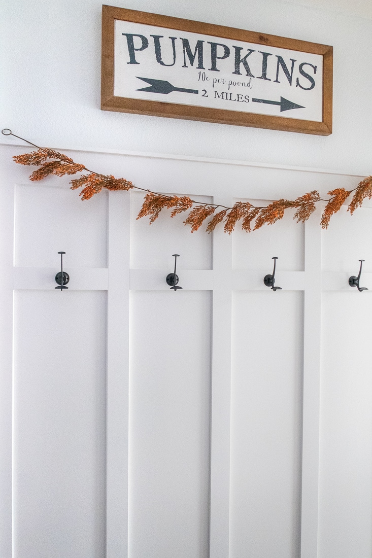 A step by step guide to installing a board and batten molding wall in a hallway with hooks to act as a mudroom. This DIY trim can add a little farmhouse decor to a boring space! #molding #diyproject