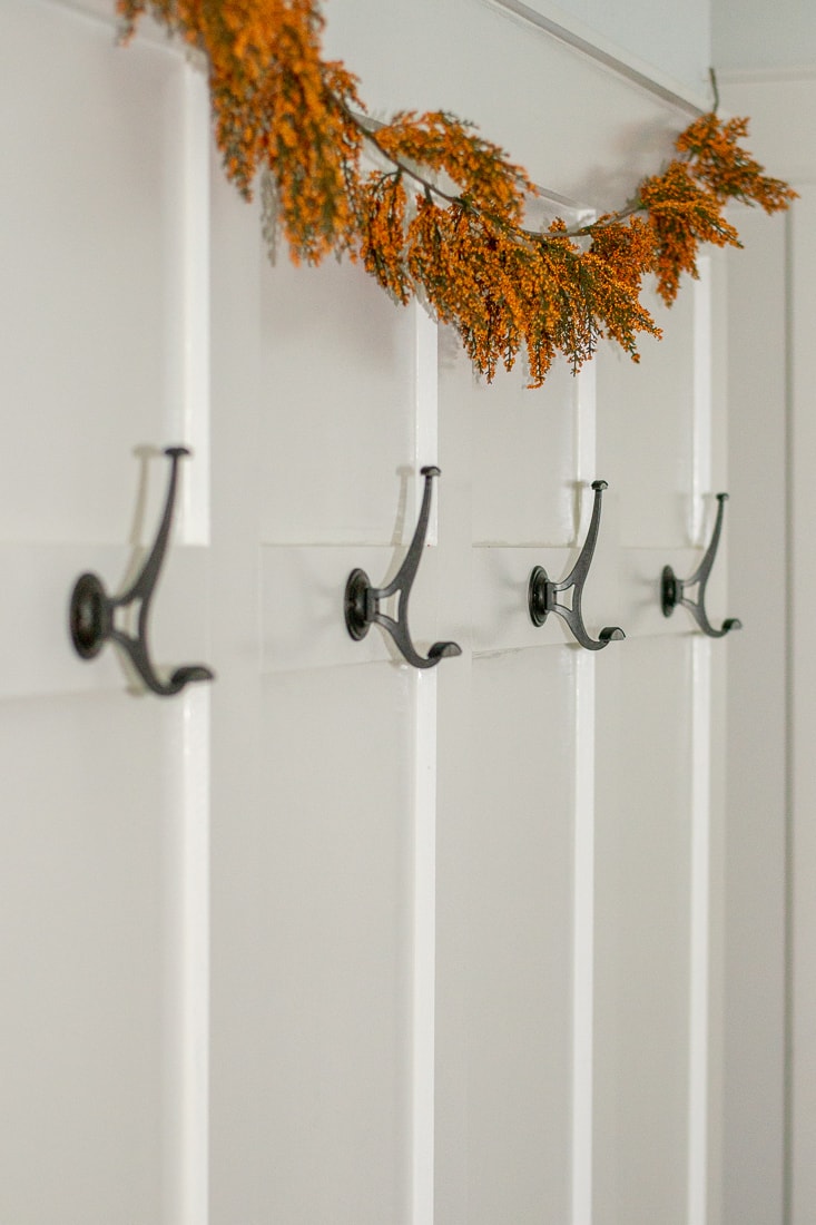 A step by step guide to installing a board and batten molding wall in a hallway with hooks to act as a mudroom. This DIY trim can add a little farmhouse decor to a boring space! #molding #diyproject