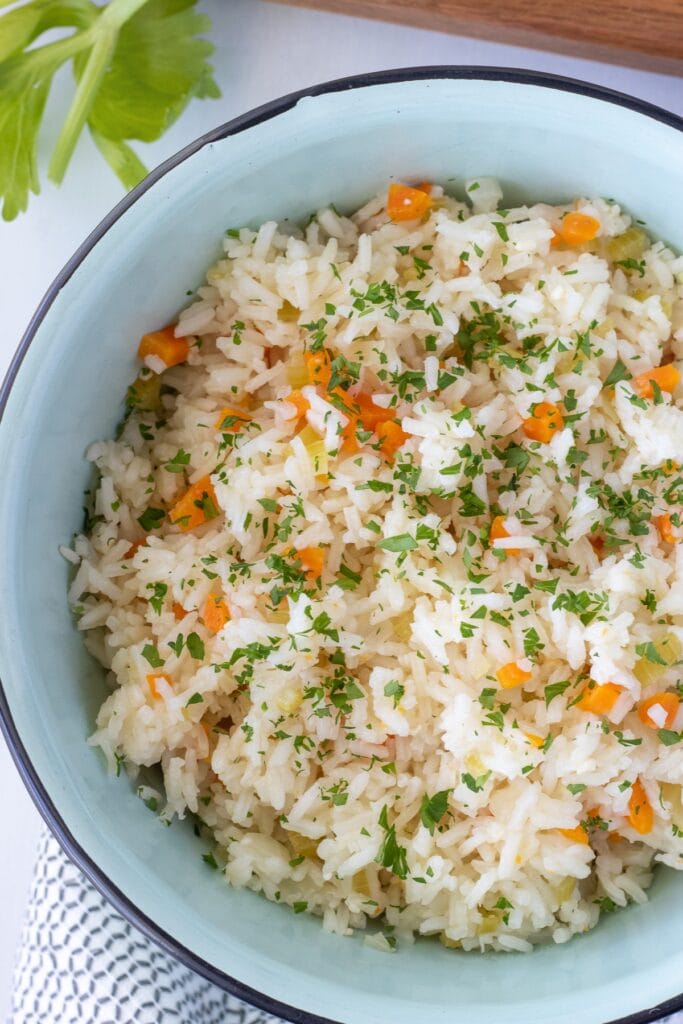 Classic steamed white rice with a big flavor boost. Vegetable steamed rice has carrots, celery, and onions are sauteed in butter or ghee and the rice is steamed with the veggies until light and fluffy. 