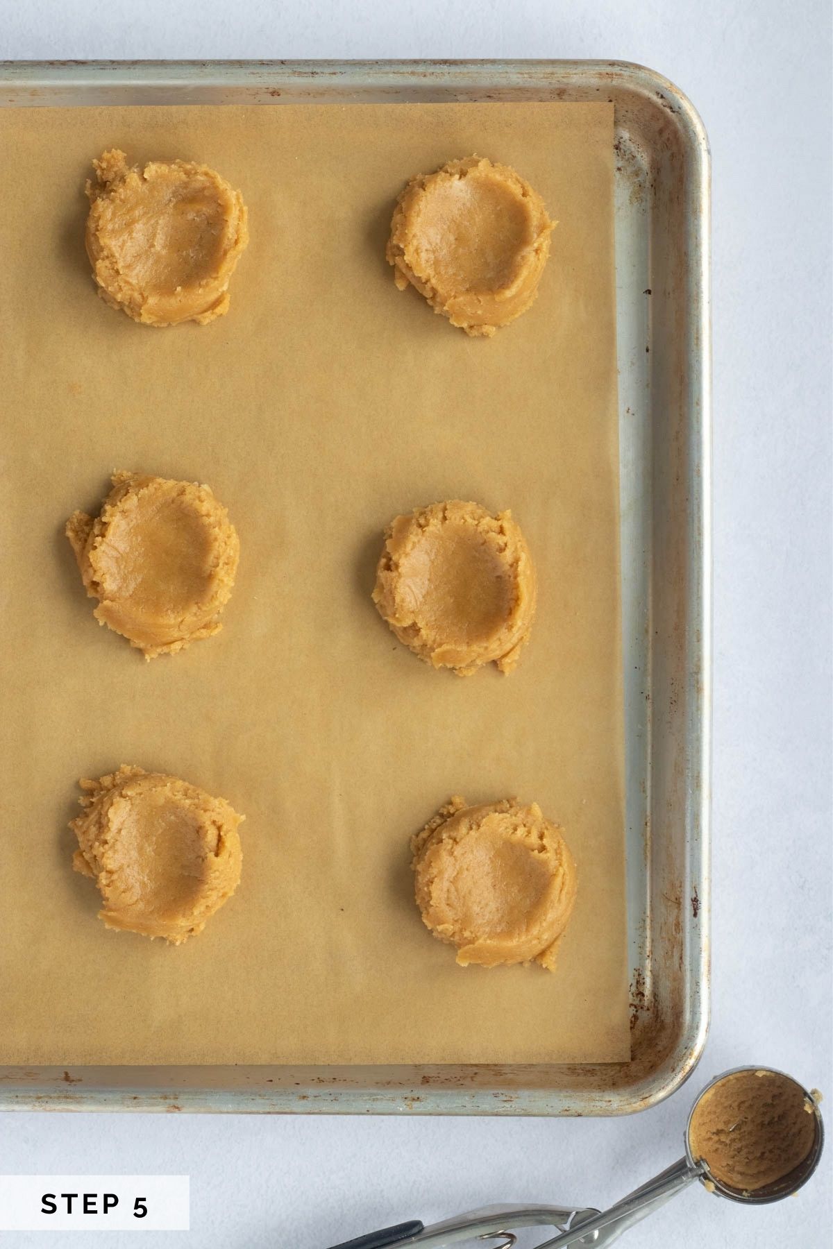 Scoop dough onto cookie sheet and press down the centers to flatten. 